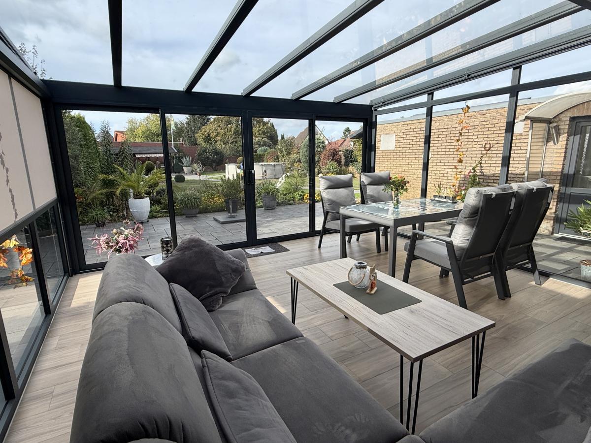 Blick vom Wintergarten auf die Terrasse und in den Garten